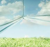pic of surreal  - Artistic surreal background representing a sky made of fabric pulled up with a hook and a meadow grass and sky above - JPG 