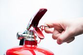 foto of pressure  - Hand pulling pin of fire extinguisher - JPG 