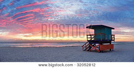 Picture or Photo of Miami South Beach sunrise with lifeguard tower and coastline with colorful cloud and blue sky.