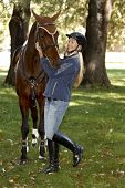 stock photo of horse  - Happy female rider embracing horse in the woods - JPG 