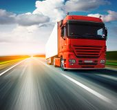 pic of over white  - Red truck on blurry asphalt road over blue cloudy sky background - JPG 