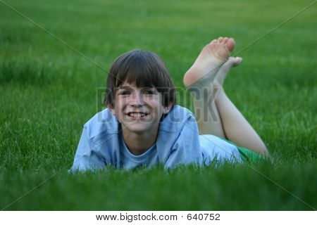 Young-Kids-Feet Picture or Photo of Young boy laying in the grass with feet up and a ...