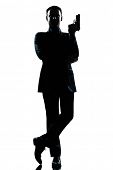 image of bond  - one caucasian secret agent in a james bond posture holding gun full length silhouette in studio isolated white background - JPG 
