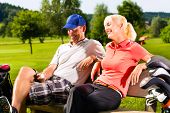 stock photo of golf  - Young sportive couple playing golf on a golf course - JPG 