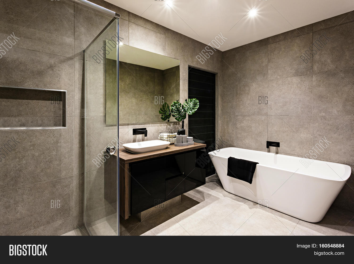 Modern bathroom with a shower area and bath tub including a wall Modern bathroom with a shower area and bath tub including a wall