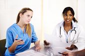 stock photo of meeting  - Portrait of a doctor talking on a meeting with two of his co-workers
** Note: Slight blurriness, best at smaller sizes - JPG 