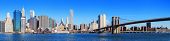 stock photo of bridge  - New York City Manhattan skyline panorama with Brooklyn Bridge and skyscrapers over Hudson River in the morning after sunrise - JPG 