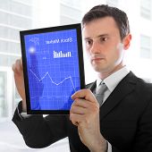 Businessman Holding A Touchpad Pc, Checking The Stock Market, Isolated On White