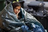 stock photo of construction worker  - poor homeless young woman wrapped in plastic tarpaulin - JPG 