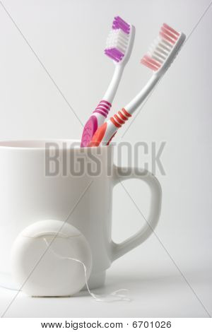 Stock photo : Two Toothbrushes In A Cup And Dental Floss