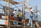 picture of construction  - Four construction workers collaboratively inspecting ongoing project - JPG 