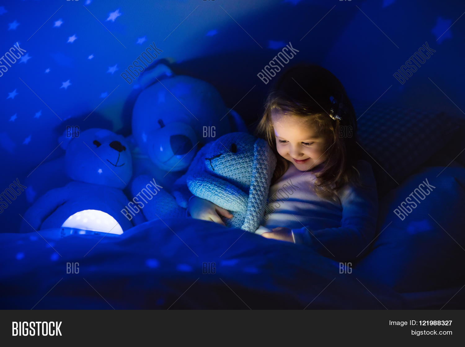Kids Bedroom Night Light little girl reading a book in bed. dark bedroom with night light Kids Bedroom Night Light little girl reading a book in bed. dark bedroom with night light