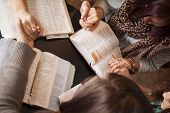 image of woman  - A group of young women bow their heads and pray with bibles - JPG 