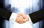 image of isp  - Two businessmen shaking hands in a technology data center - JPG 