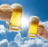 image of blue sky  - toasting with beers against clear blue sky - JPG 
