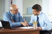 picture of meeting  - senior and junior businessman discuss something during their meeting - JPG 