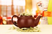 stock photo of  photo  - Dried herbs in teapot on wooden table - JPG 
