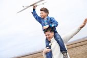 image of youngster  - Photo of happy boy with toy airplane and his father playing outside - JPG 