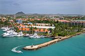 stock photo of opulence  - a speedboat cruises by a helicopter landing pad in a marina in Oranjestad - JPG 