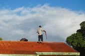 foto of pressure  - Man cleaning the roof with a high pressure water jet - JPG 