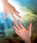 foto of religion  - A hand is reaching out or grabbing for help from another hand in the sky - JPG 