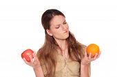 stock photo of choice  - Isolated studio shot of a Caucasian businesswoman making a difficult choice between an apple and orange - JPG 
