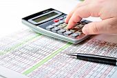 pic of outcome  - Tax forms spread sheet with pen and calculator.
** Note: Shallow depth of field - JPG 