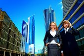 stock photo of talking  - Business woman and business man is talking on mobile phone in front of skyscrapers - JPG 