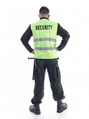 picture of security  - Security man wearing black uniform and yellow reflective vest standing confidently with arms resting on hips - JPG 