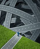 stock photo of group  - Journey confusion and facing challenges with a businessman at the edge of a cliff in front of a group of tangled three dimensional roads and highwaysas a business concept of planning and managing adversity - JPG 