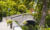 stock photo of bridge  - A beautiful stone arch bridge in a forest setting in Gatineau across the river from Ottawa - JPG 