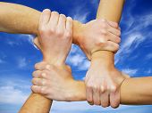 picture of teamwork  - Linked hands on a white background symbolizing teamwork and friendship - JPG 