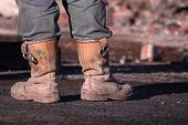 foto of construction worker  - workmans boots demolition worker taking a break looking over his work  - JPG 