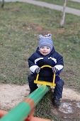 stock photo of seesaw  - The joyful toddler is swinging on seesaw - JPG 