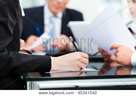 Picture or Photo of Business - meeting in an office, lawyers or attorneys discussing a document or contract agreement