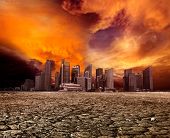 image of earth  - City overlooking desolate desert landscape with cracked earth - JPG 