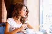 stock photo of restaurant  - Portrait of young pretty woman sitting in restaurant - JPG 