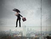 pic of businessmen  - Businessman keeping his balance on a rope over a big city - JPG 