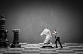stock photo of businessmen  - Young businessman moving a knight on a chessboard - JPG 