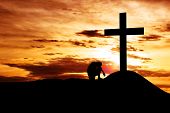 foto of religion  - Dramatic sky scenery with a mountain cross and a man seating hopelessly under the cross - JPG 