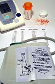 picture of bloodpressure  - this is an image of a home blood pressure monitor with a health log and pills - JPG 