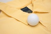 foto of golf  - Golf Ball on Yellow Polo Shirt With Golf Sign on Tag - JPG 