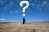 image of businessmen  - businessman standing alone at the field with a lot of questions in his mind - JPG 