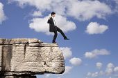 pic of failure  - Businessman making a danger and step falling from a rock - JPG 