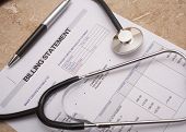 image of medical doctors  - Stethoscope on medical billing statement on table all text is anonymous - JPG 