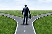 stock photo of equality  - Career decision for a business man at a cross roads standing at a horizon with grass and blue sky showing a fork in the road representing the concept of a strategic dilemma choosing the right direction to go when facing two equal or similar job options - JPG 