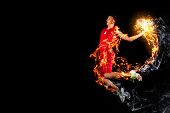 stock photo of competition  - Male basketball player jumping and practicing with a ball - JPG 