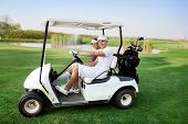 stock photo of golf  - Couple in  driving buggy on golf course - JPG 