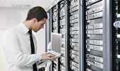 image of isp  - young it engeneer business man with thin modern aluminium laptop in network server room - JPG 