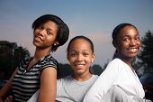 stock photo of teenager  - Three beautiful smiling teenage African American girls outdoors - JPG 